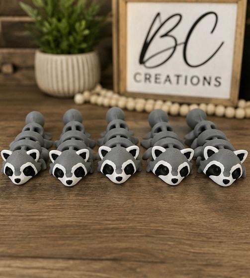 Gray ceramic raccoon figurines in a row